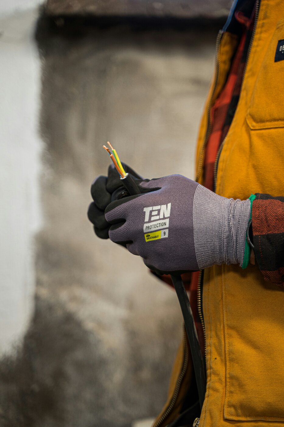 Elektriker bei der Arbeit — Kabel mit Schutzhandschuhen